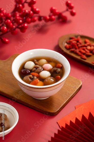 Fototapeta Red and white tangyuan with syrup soup, dried longan pulp, red dates for Chinese lunar new year.