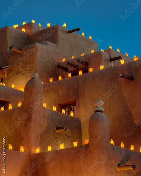 Obraz Large adobe building decorated with luminaria for the holidays