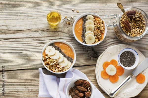 Obraz Healthy breakfast. Carrot Banana smoothie with granola and chia seeds