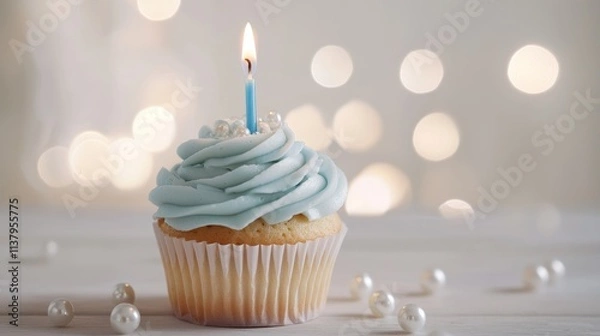 Fototapeta Elegant Blue Cupcake with Lit Candle and Pearl Decorations on Bokeh Background