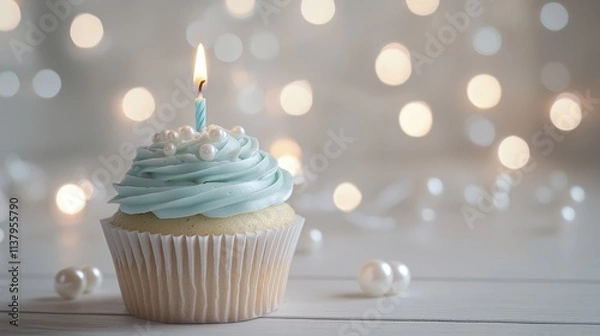 Fototapeta Elegant Blue Cupcake with Lit Candle and Pearl Decorations on Bokeh Background