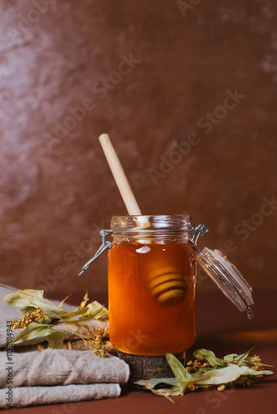 Fototapeta A jar of honey with dry linden leaves