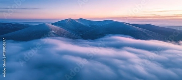 Fototapeta Aerial view of the picturesque Beskid Mountains shrouded in clouds at sunrise with vibrant colors illuminating the landscape
