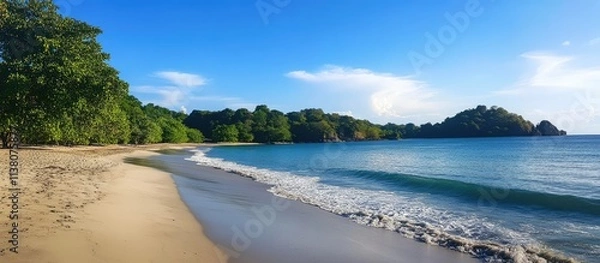 Fototapeta Scenic tropical beach with clear waters and lush greenery ideal for relaxation and vacation enjoyment