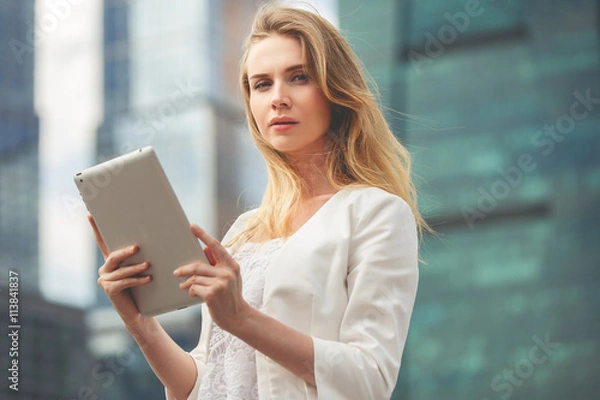 Fototapeta Beautiful woman using electronic tab in the street
