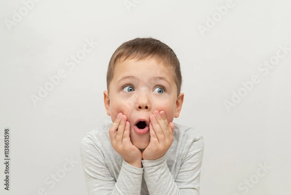 Obraz portrait of a child on a white background. surprised little boy with blue eyes, emotion of surprise and surprise