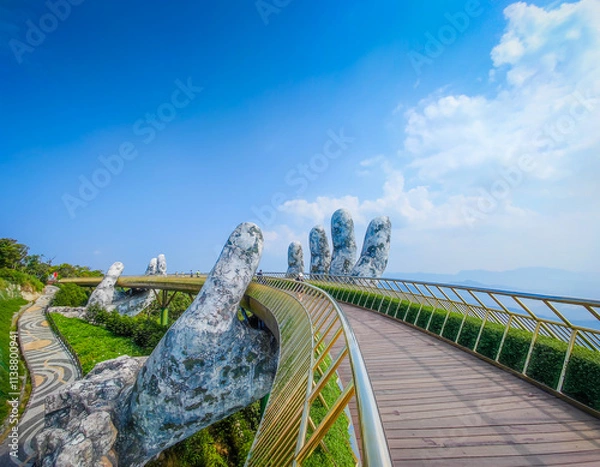 Obraz Golden Bridge in Ba Na hills, Da Nang, Vietnam on a sunny day. Lifted by two giant concrete hands. Iconic world famous bridge in the mountains