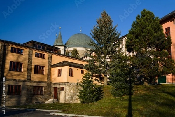 Fototapeta View of the towers and dome of the basilica through the pilgrimage houses. Hostyn. Czech Republic.