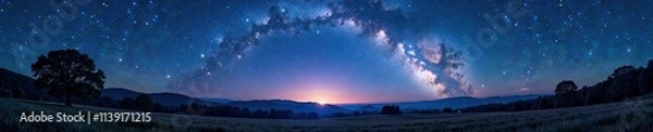Fototapeta Starry night sky with Milky Way arch shining above a field of trees and hills, outer space, hills
