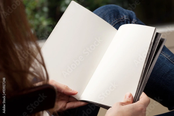 Obraz Blank spread, open book in woman's hands 