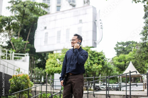 Fototapeta Businessman Calling Using Smartphone While Looking Away