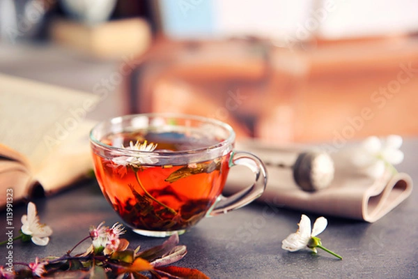 Fototapeta Cup of tea with flowers on brown table