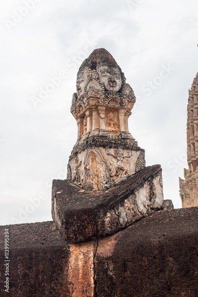 Fototapeta Wat Phra Si Rattana Mahathat Chaliang Khmer Ruin with a walking Buddha in classical Sukhothai style and apsara on front mini-prang