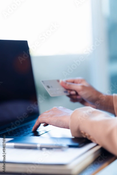 Obraz woman holding credit card, and typing on laptop, to shop, and pay via internet, concept of online shopping and services, ordering products at home.
