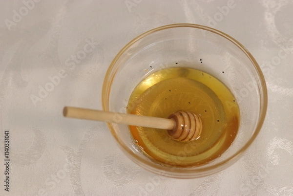 Fototapeta Honey bee in a bowl of honey.A bowl with honey and a dipper to take honey

