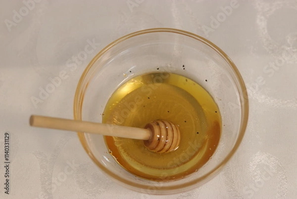 Fototapeta Honey bee in a bowl of honey.A bowl with honey and a dipper to take honey
