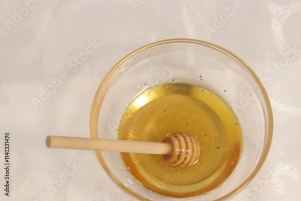 Fototapeta Honey bee in a bowl of honey.A bowl with honey and a dipper to take honey

