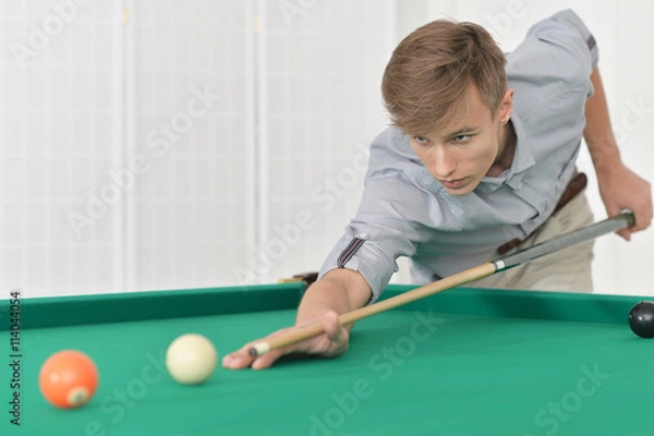 Obraz man playing billiards in  billiard club