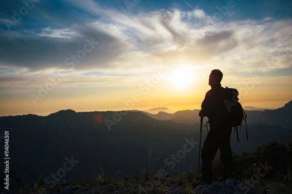 Fototapeta Back view of unrecognizable mountaineer