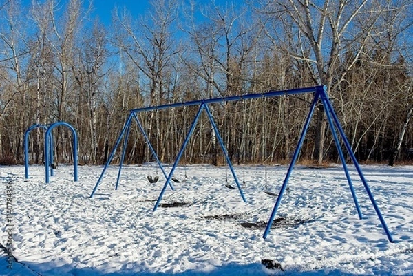 Fototapeta Swings in winter playground with snow