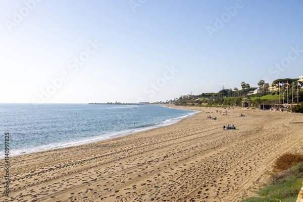 Fototapeta Photo of the beautiful beach front in the town of Sitio de Calahonda in Mijas Spain showing the sandy beach in the month of December on a sunny day