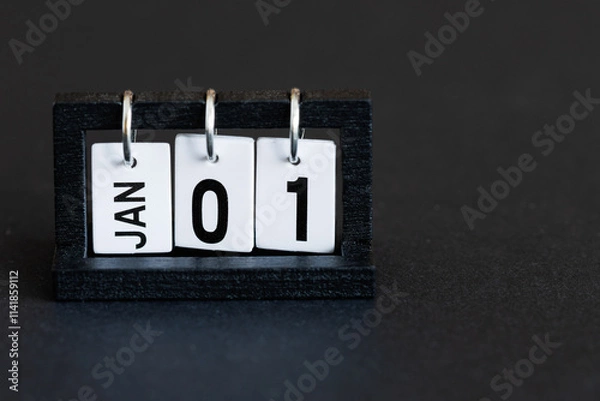 Fototapeta A perpetual desktop calendar on a black background. January 1st. The first day of the new year.