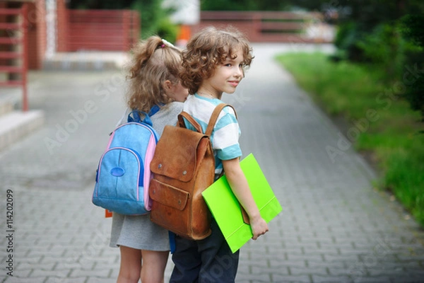 Fototapeta Two little pupil of elementary school, boy and girl, stand having joined hands