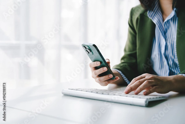 Fototapeta Typing on a smartphone Working online on laptop, computer and smartphone on white table at office. Facebook chat. Web meeting. Blogger. Journalist writing an article. online job idea