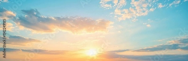 Fototapeta The sky is painted with an orange sunrise and soft clouds, creating a beautiful natural panorama.
