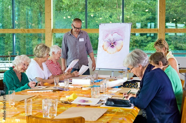 Fototapeta Teacher with group of students in painting class.