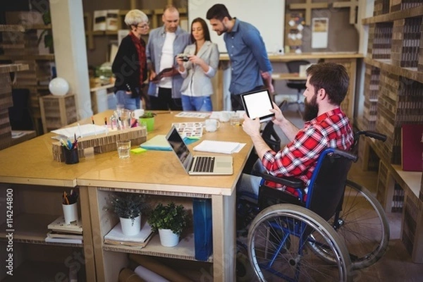 Fototapeta Disabled businessman using digital tablet at desk 