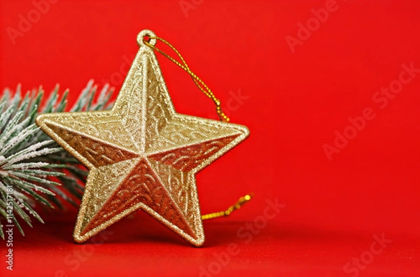 Obraz golden christmas star ornament with pine branch on red festive background