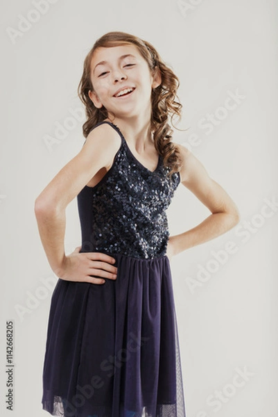 Fototapeta Smiling girl with sparkly dress posing with hands on hips