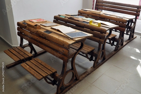 Fototapeta An old wooden school desk on display in a museum. We also see teaching aids.