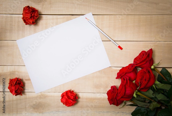 Fototapeta blank sheet of paper on the table beside him a bouquet of red ro