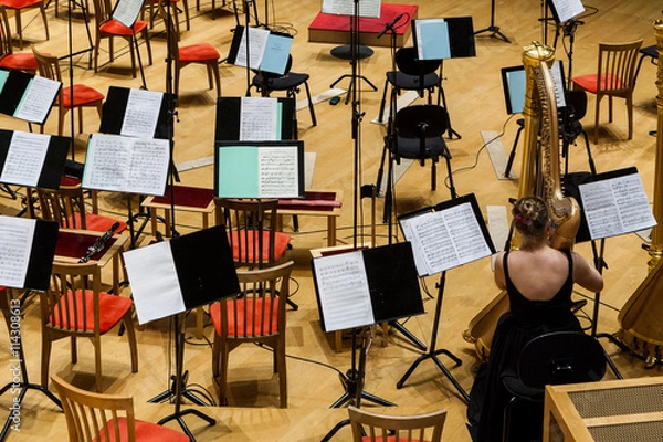 Fototapeta The orchestra pit in a concert hall. Chairs, musical instruments and wooden walls.