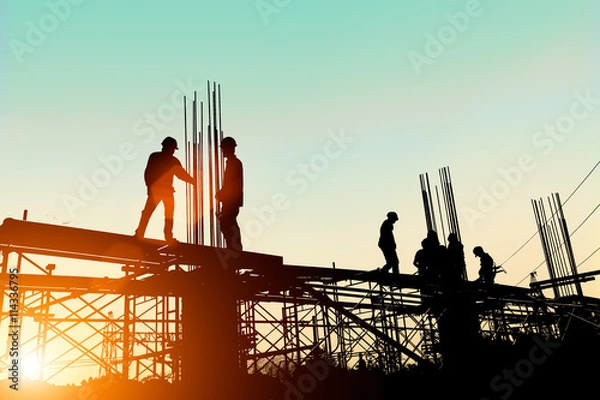 Obraz Silhouette engineer standing orders for construction crews to wo