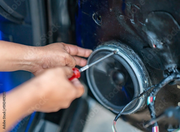 Fototapeta Technician installing car speaker on damping material for noise insulation .