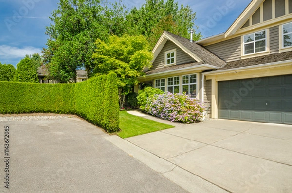 Obraz Garage door in luxury house with trees and nice landscape in Summer in Vancouver, Canada, North America. Day time on June 2024.