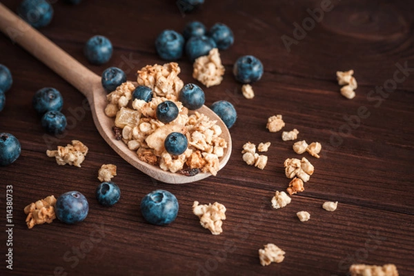 Fototapeta muesli with blueberries on a wooden spoon