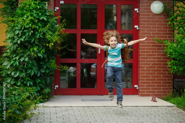 Fototapeta Little first grader rejoices to the beginning of summer vacation.