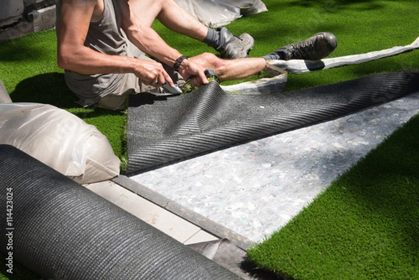 Obraz professional gardener is cutting artificial turf to fit