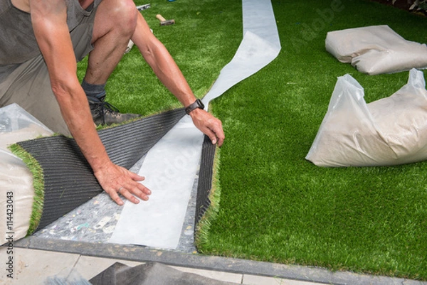 Obraz professional gardener is cutting artificial turf to fit