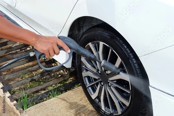 Obraz Washing your car with a high-pressure water gun.