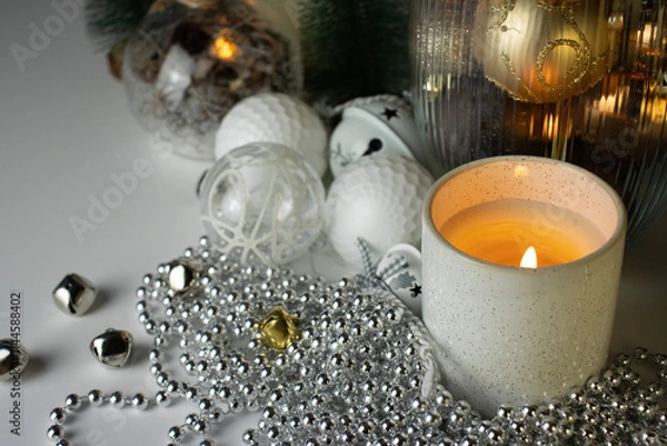 Fototapeta New Year decorations and candles on a white background. Christmas decorations close-up. Postcard, background for postcard, copy space