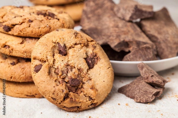 Fototapeta Chocolate chip cookies with chocolate parts on wooden table
