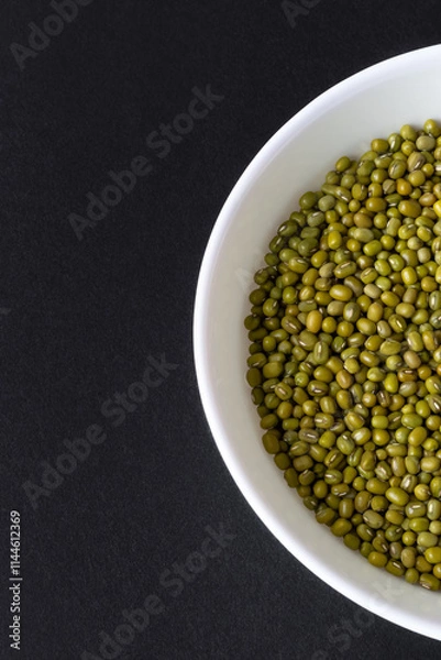 Fototapeta Top view of mung beans  in white bowl on black background
