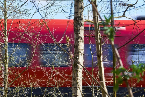 Fototapeta Low angle photography of a red local train in the Greater Copenh