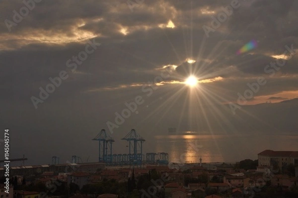 Fototapeta Rijeka city new crains for harbour and containers. Modern Crain that moves with to remote. Most modern Crain in Europe. Sunset over Rijeka harbour. Croatia