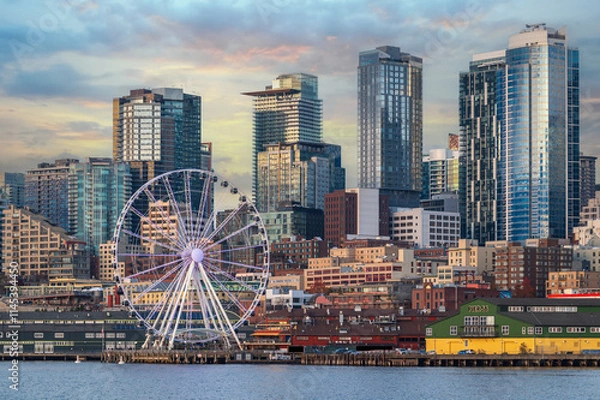 Obraz Seattle skyline with skyscrapers and a ferris wheel during a lovely sunset reflecting off the modern buildings.  View seen after the removal of the Alaskan Way Viaduct and a renovated waterfront.